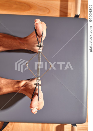 Young man Using Yoga Belt While Doing Exercise On Fitness Mat. High quality photo 94934802