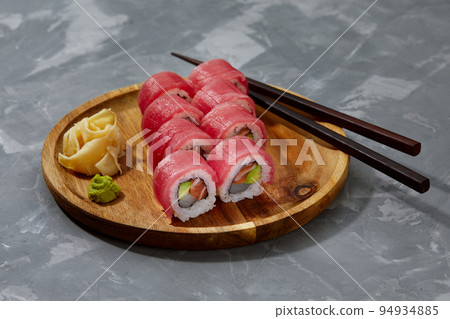 Sushi roll Maguro with tuna, shrimp, salmon, smoked eel, avocado, philadelphia cheese on black background. Sushi menu. Japanese food. Sushi roll Maguro with tuna, shrimp, salmon, smoked eel, avocado, philadelphia cheese on black background. Sushi menu. Japanese food. 94934885