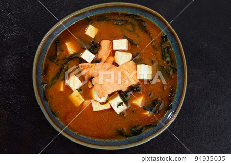 Japanese miso soup in a gray bowl on the black table. horizontal view from above Japanese miso soup in a gray bowl on the black table. horizontal view from above 94935035