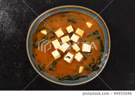 Japanese miso soup in a gray bowl on the black table. horizontal view from above Japanese miso soup in a gray bowl on the black table. horizontal view from above 94935046
