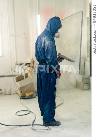 worker powder coats steel parts in a spray booth worker powder coats steel parts in a spray booth 94935053
