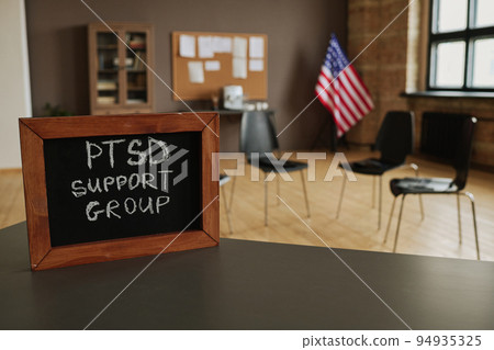 Small chalkboard with notice about PTSD support group on table in studio 94935325