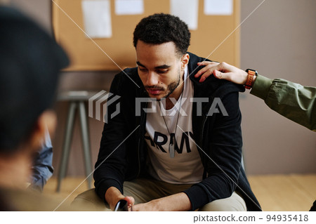 Hand of young man on shoulder of unhappy and depressed male attendant 94935418