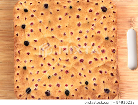Homemade freshly baked blueberry and redcurrant cake, closed with round holes. 94936232