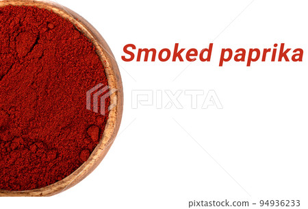 Smoked paprika in a wooden bowl on a white background with the inscription. 94936233