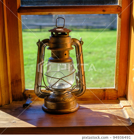 a very old kerosene lamp in the house by the window a very old kerosene lamp in the house by the window 94936491