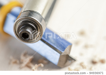 Copying the router bit. Cutter for trimming wooden edges. Copy-milling tool with steel bearing. Cutters lie on wood shavings Copying the router bit. Cutter for trimming wooden edges. Copy-milling tool with steel bearing. Cutters lie on wood shavings 94936971