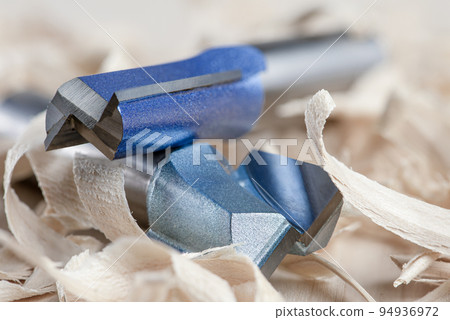 Copying the router bit. Cutter for trimming wooden edges. Copy-milling tool with steel bearing. Cutters lie on wood shavings 94936972