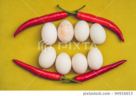 Eggs and red pepper in the form of a mouth with teeth. One of the teeth is sick in the form of a cracked egg. Sick tooth concept Eggs and red pepper in the form of a mouth with teeth. One of the teeth is sick in the form of a cracked egg. Sick tooth concept 94938853