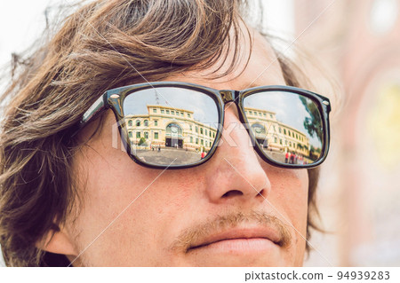 A man looks at Saigon Central Post Office on blue sky background in Ho Chi Minh, Vietnam. Steel structure of the gothic building was designed by Gustave Eiffel. 94939283