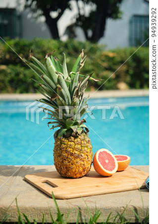 pineapple and grapefruit on the edge of the pool 94939292