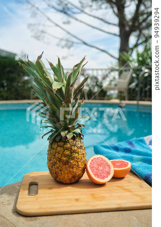 pineapple and grapefruit on the edge of the pool pineapple and grapefruit on the edge of the pool 94939294