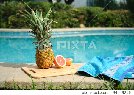 pineapple and grapefruit on the edge of the pool pineapple and grapefruit on the edge of the pool 94939296