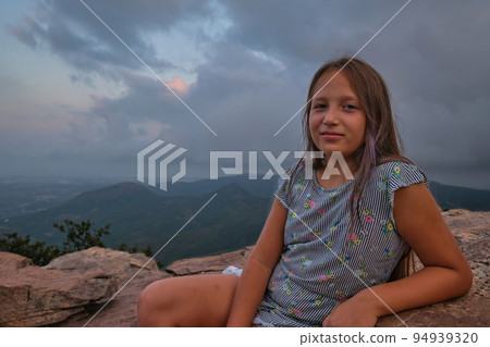 portrait of a girl against the sky and mountains 94939320
