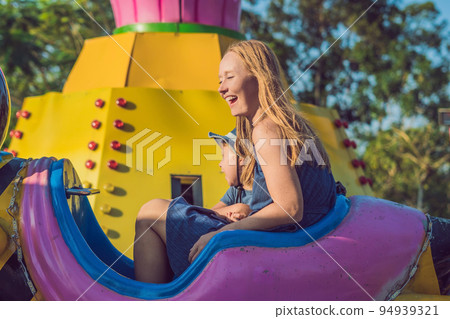 Mom and son having fun at an amusement park Mom and son having fun at an amusement park 94939321