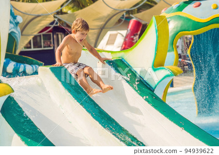 Boy is having fun in the water park Boy is having fun in the water park 94939622