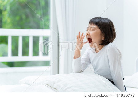 sleep deprived girl yawning in bed sleep deprived girl yawning in bed 94939778