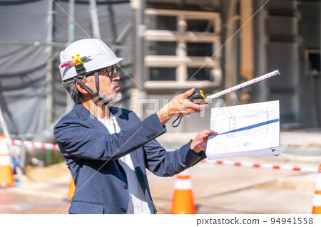 將設計圖紙與施工現場進行比較的施工主管白髮鬍鬚 94941558
