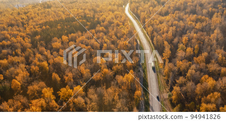 an autumn road stretching away to the horizon. Autumn forest landscape with orange foliage aerial drone top, atmospheric mood panorama an autumn road stretching away to the horizon. Autumn forest landscape with orange foliage aerial drone top, atmospheric mood panorama 94941826