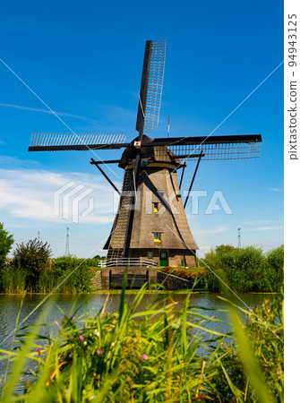 Windmill at Kinderdijk along riverside Windmill at Kinderdijk along riverside 94943125