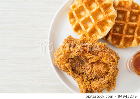 fried chicken waffle with honey or maple syrup fried chicken waffle with honey or maple syrup 94943279