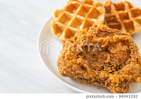 fried chicken waffle with honey or maple syrup 94943292