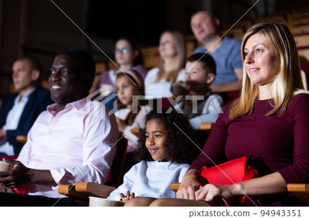 International family enjoys watching comedy in cinema hall International family enjoys watching comedy in cinema hall 94943351