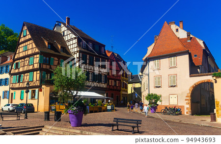 Summer cityscape of Colmar overlooking cobbled streets with typical townhouses 94943693