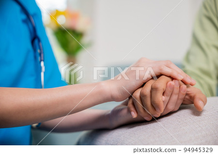 Young woman helping hold hands offering her senior man 94945329