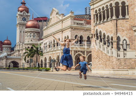 Mom and son on background of Sultan Abdul Samad Building in Kuala Lumpur, Malaysia. Traveling with children concept 94946415