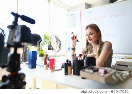 Young female blogger is recording tutorial video for blog about cosmetics 94947011