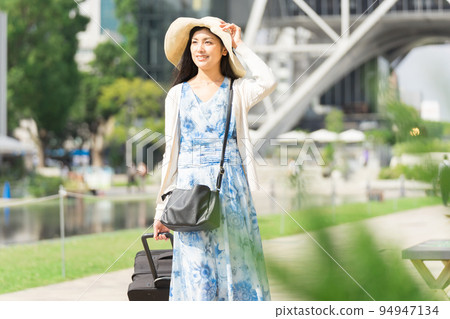 A young woman pulling a suitcase and sightseeing in Nagoya 94947134