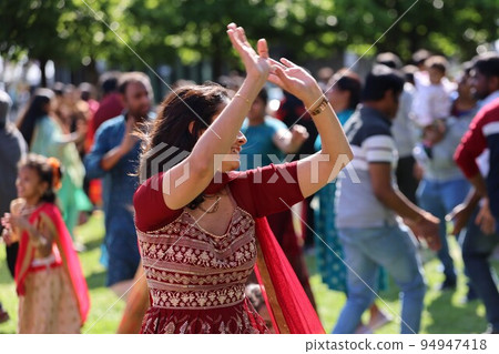 Joyful Indian woman dancing at a festival 94947418