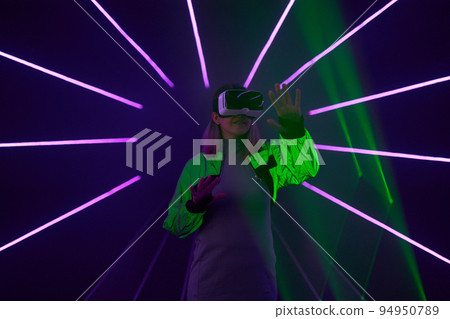 Woman is using virtual reality headset to access in metaverse. 94950789