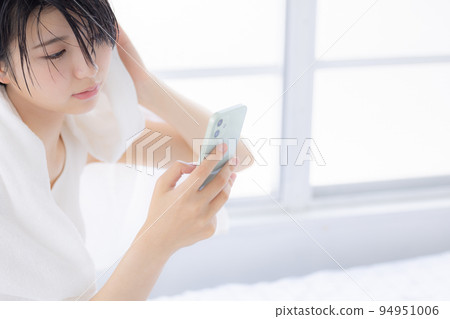Beauty image A young woman looking at her smartphone Beauty image A young woman looking at her smartphone 94951006