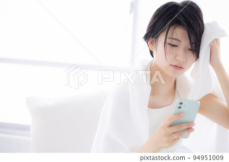 美女形象 一個年輕的女人看著她的智能手機 美女形象 一個年輕的女人看著她的智能手機 94951009