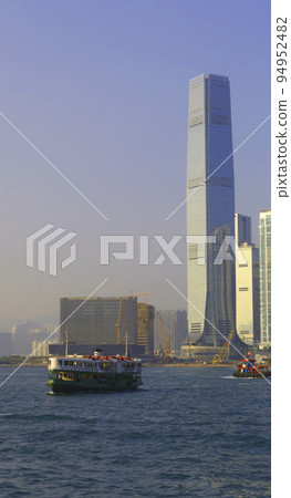 Star ferry in front of high-rise buildings in Hong Kong 94952482