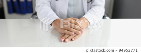 Doctor hands are folded on desktop in clinic 94952771