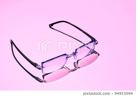 Black framed eyeglasses on pink bright background 94953094