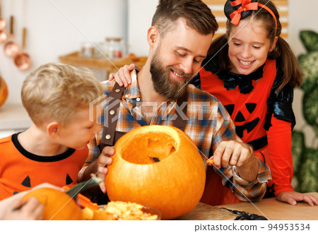 Children and dad making Jack-o-Lantern together at home, carving Halloween pumpkin 94953534