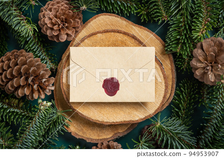 Christmas blank sealed envelope between fir branches and pine cones on green top view 94953907