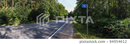 highway paved road through the forest and a column 94954612