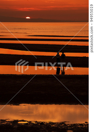 The sunset at Matama Beach in Bungotakada City, Oita Prefecture and the silhouette of a person watching the sunset 94955019