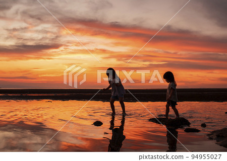 Matama beach sunset and silhouette of a child playing on the beach 94955027