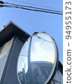 The blue sky reflected in the cracked curved mirror 94955173