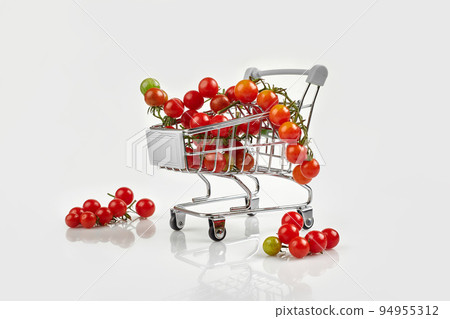 Mini shopping cart full with cherry tomatos on white background Mini shopping cart full with cherry tomatos on white background 94955312