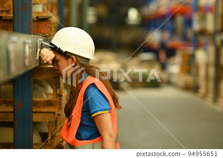 Warehouse workers wearing safety hardhat working on retail warehouse full of packed boxes and goods 94955651