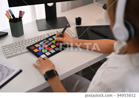 Young creative woman using graphic tablet and professional computer working for design project at home office Young creative woman using graphic tablet and professional computer working for design project at home office 94955652