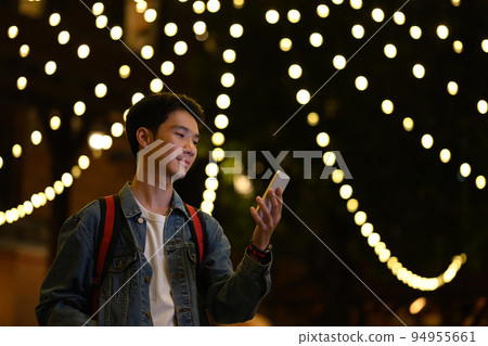 Portrait of hipster man standing in city avenue with blurred night street lights background Portrait of hipster man standing in city avenue with blurred night street lights background 94955661