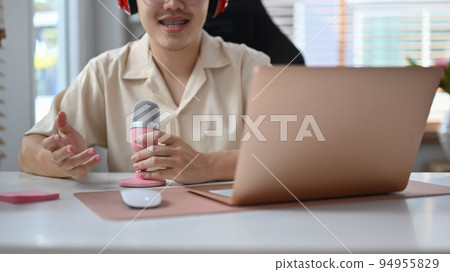 Image of radio host using microphone and laptop to recording podcast in home studio. Radio, podcasts and technology concept 94955829